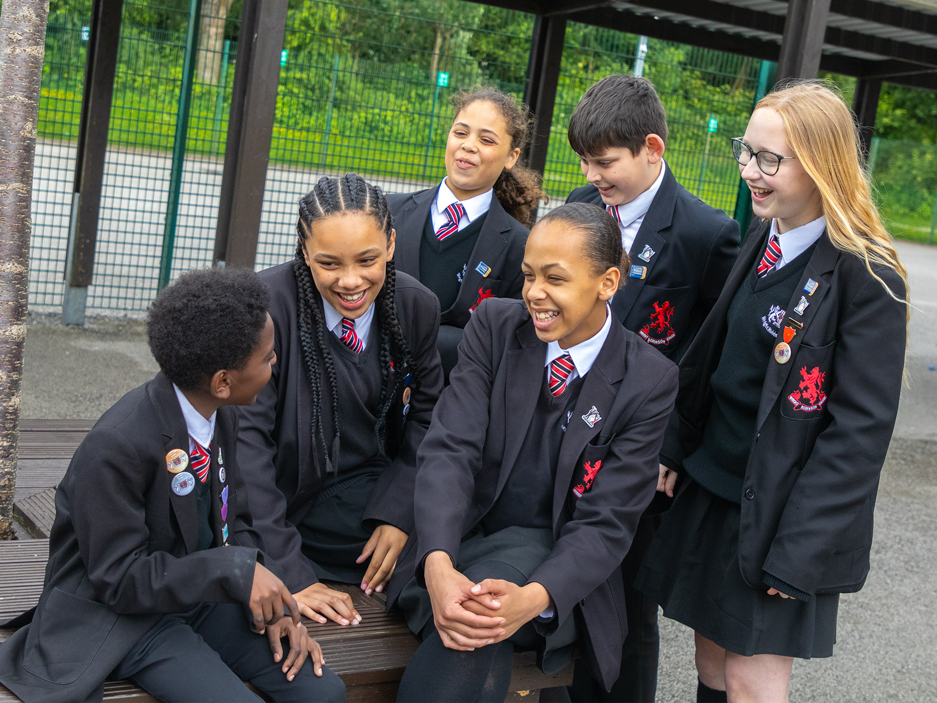 Image shows a group of 6 young students sitting together. They are all wearing the uniform for Wright Robinson College.