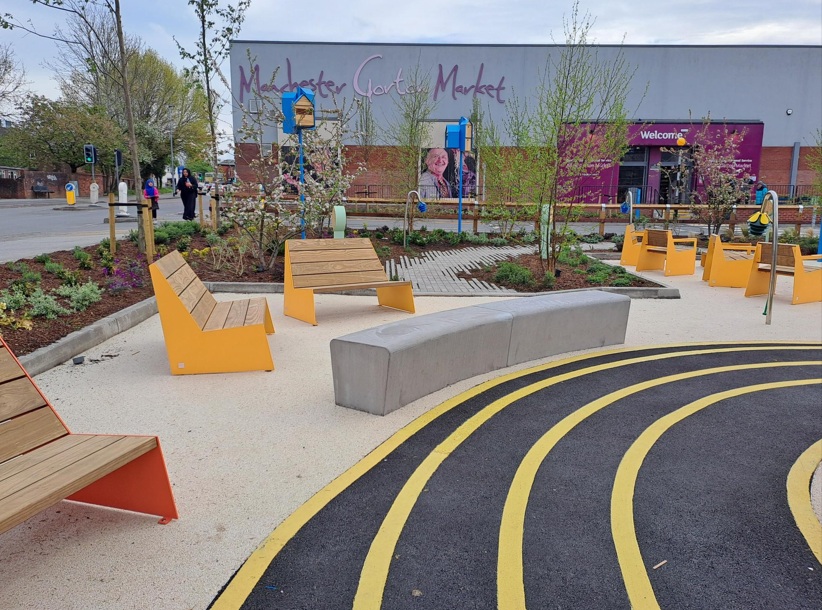 Gorton square with the Gorton Market Hall and outdoor seating area 