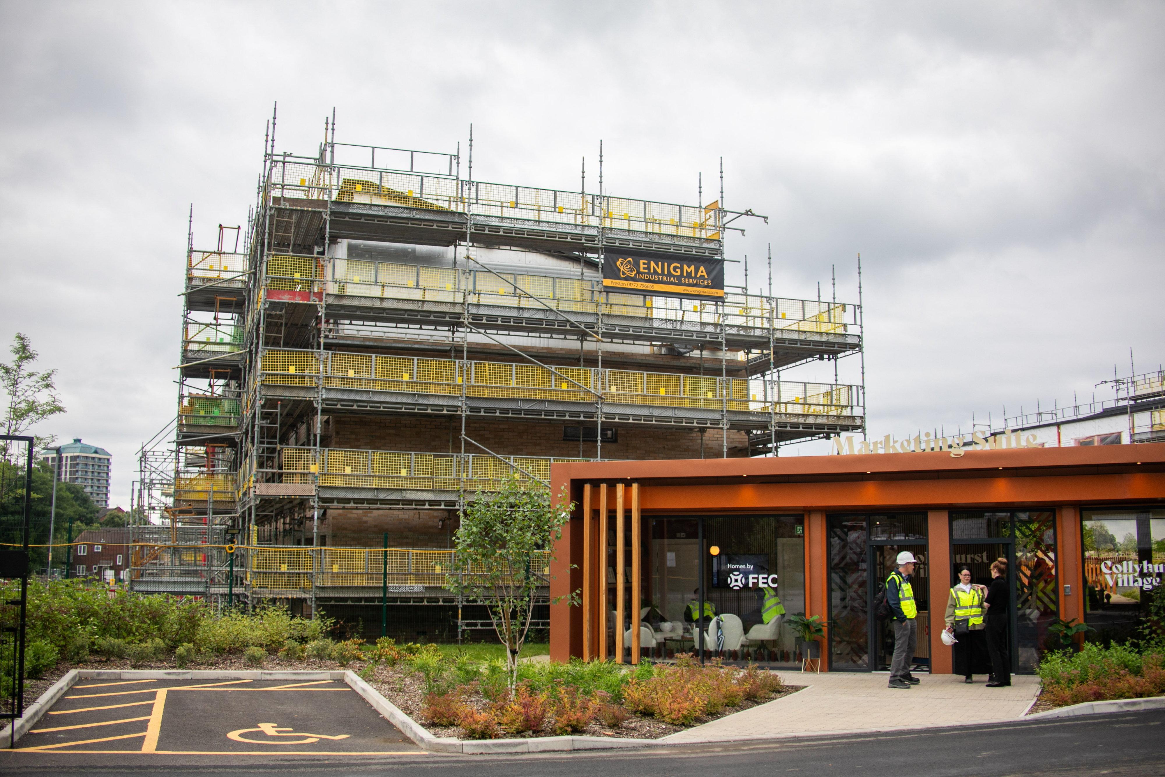 A progress picture of Collyhurst Village with a large residential development covered in scaffolding