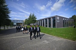 Image shows a group of students at the main entrance to the school