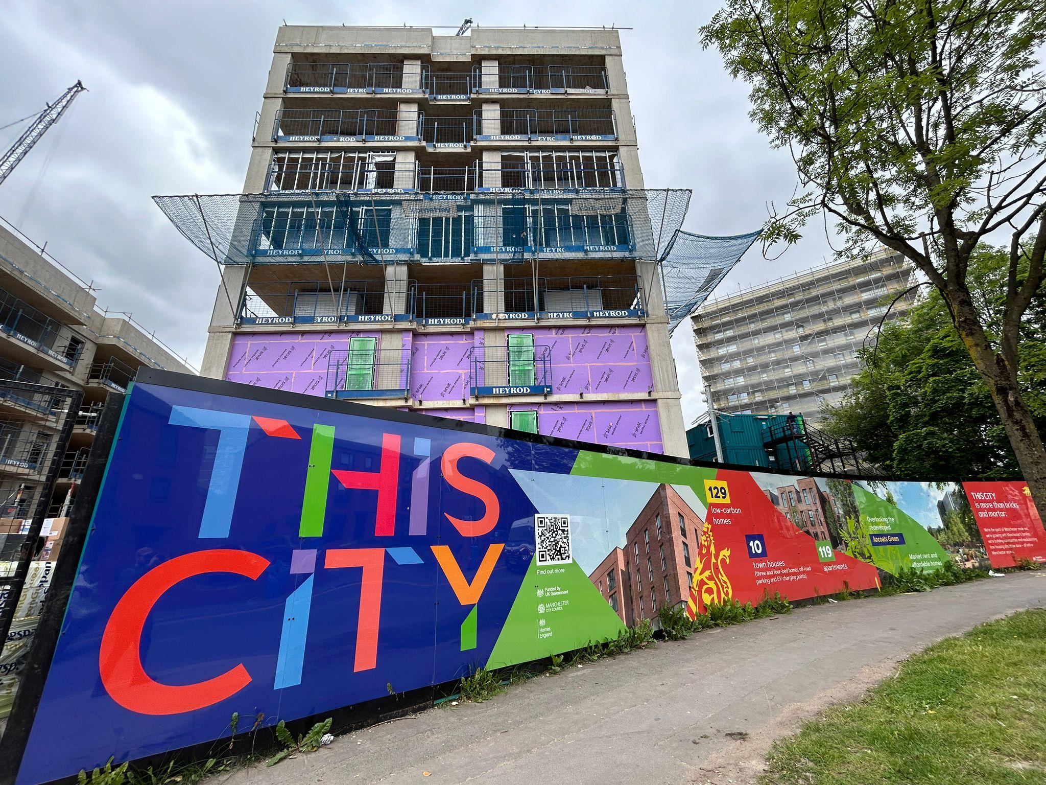 photo from site visit showing the This City branding in the foreground and an uncomplete multistorey building behind