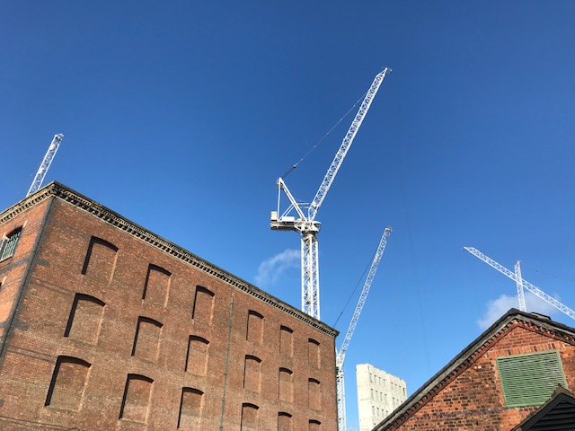 photograph of an industrial building with scaffolding and a blue sky