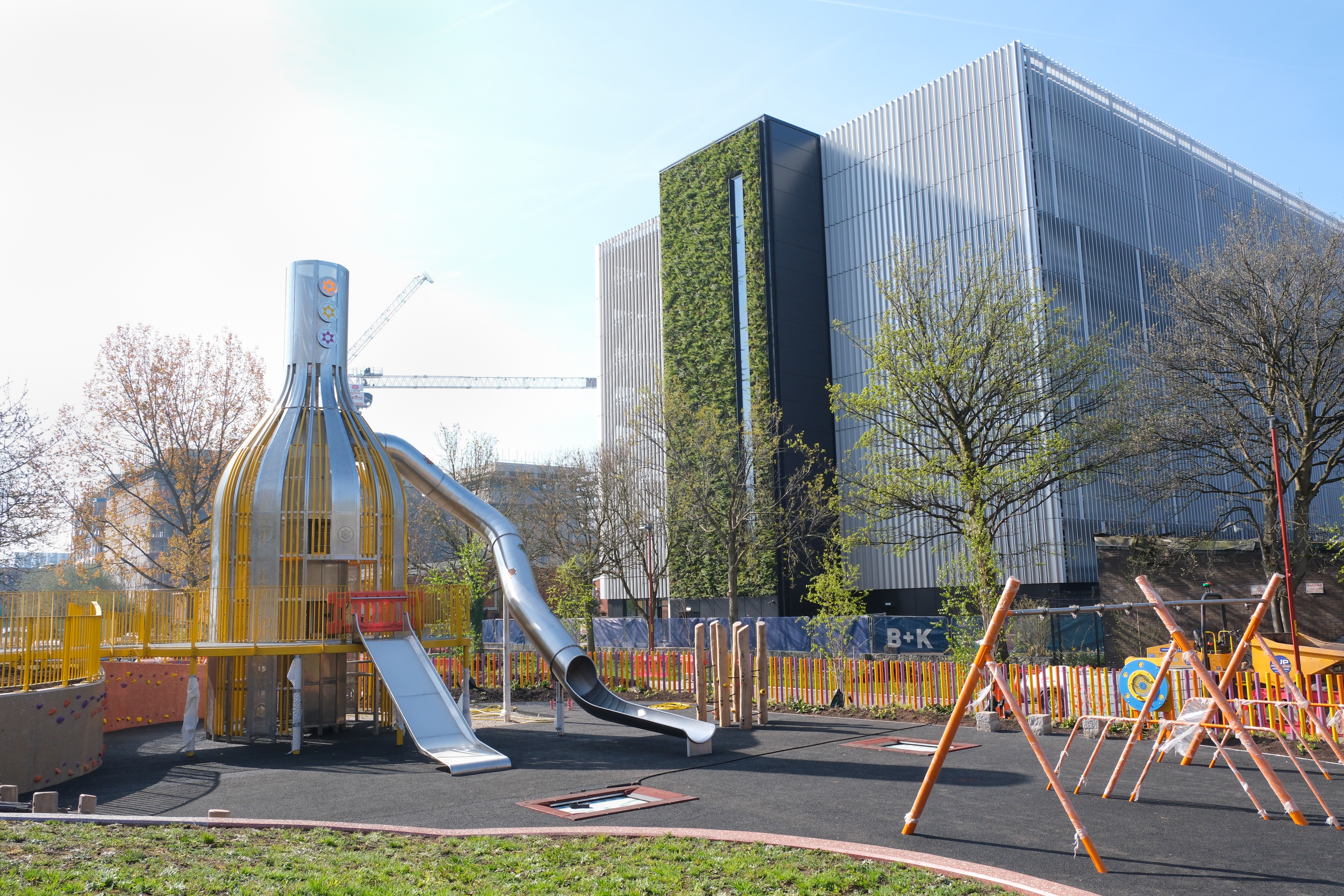The playground area of Ancoats Green with a large building in the background