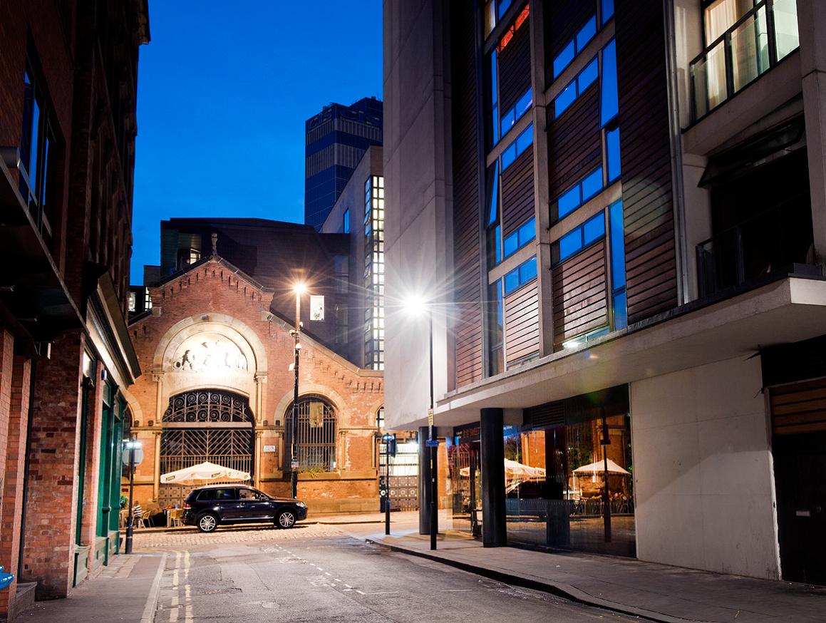 An image of a narrow road with tall buildings beside 