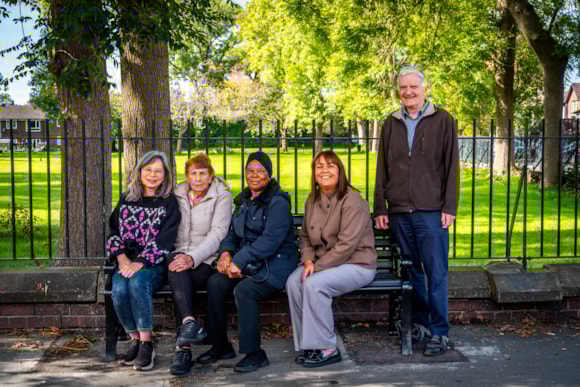People sitting in a row on a bench