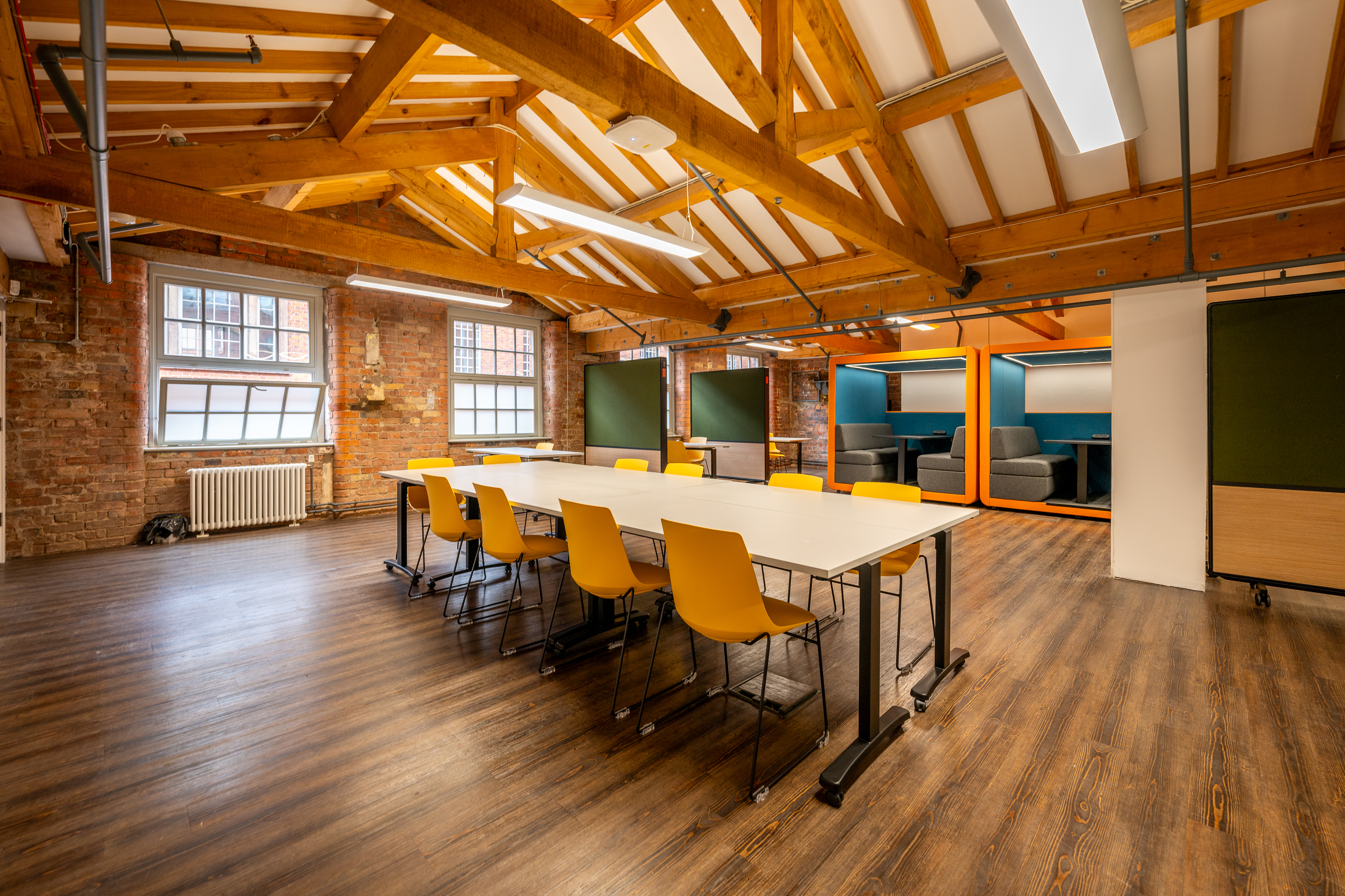 Interior of the Generator Hub Ancoats showing meeting table and chairs and pods