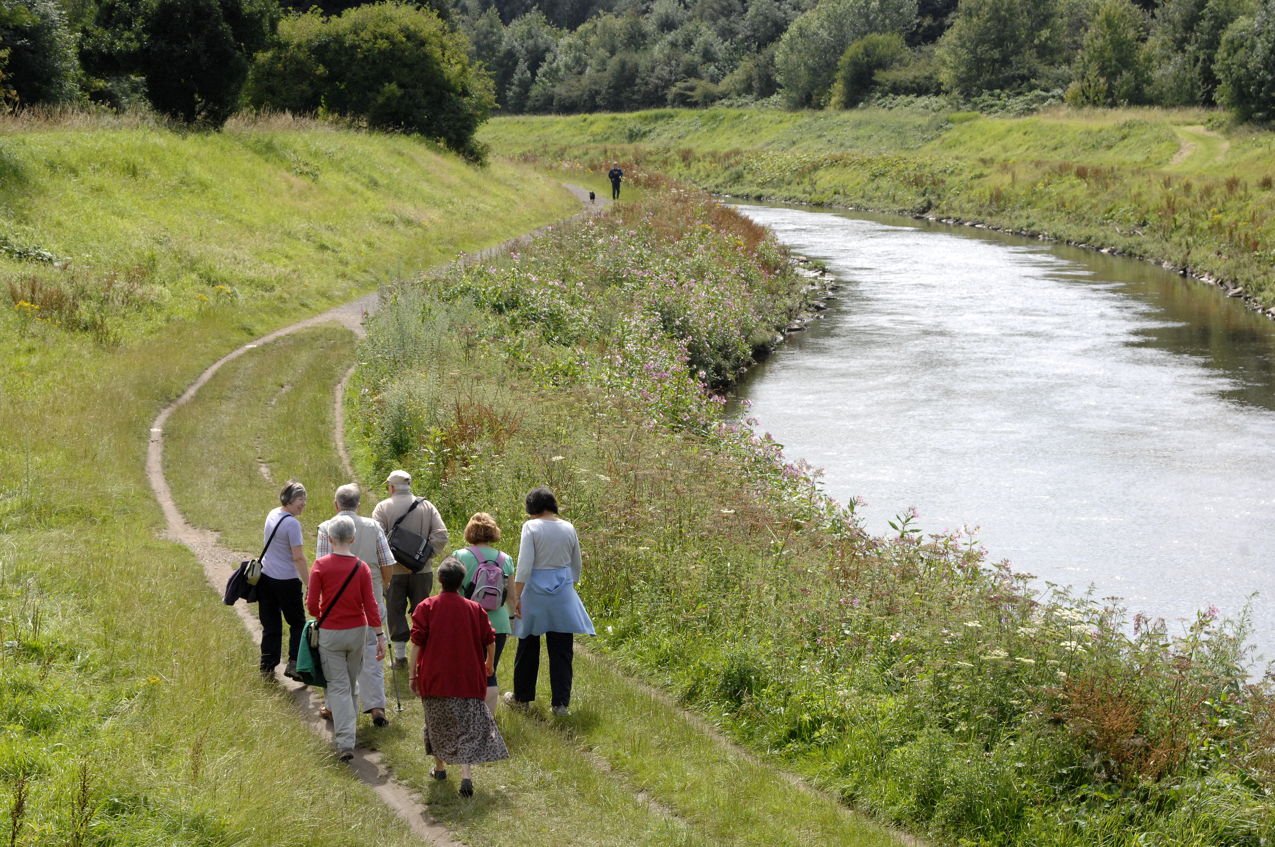 Photo of a group of people walking along the River Mersey