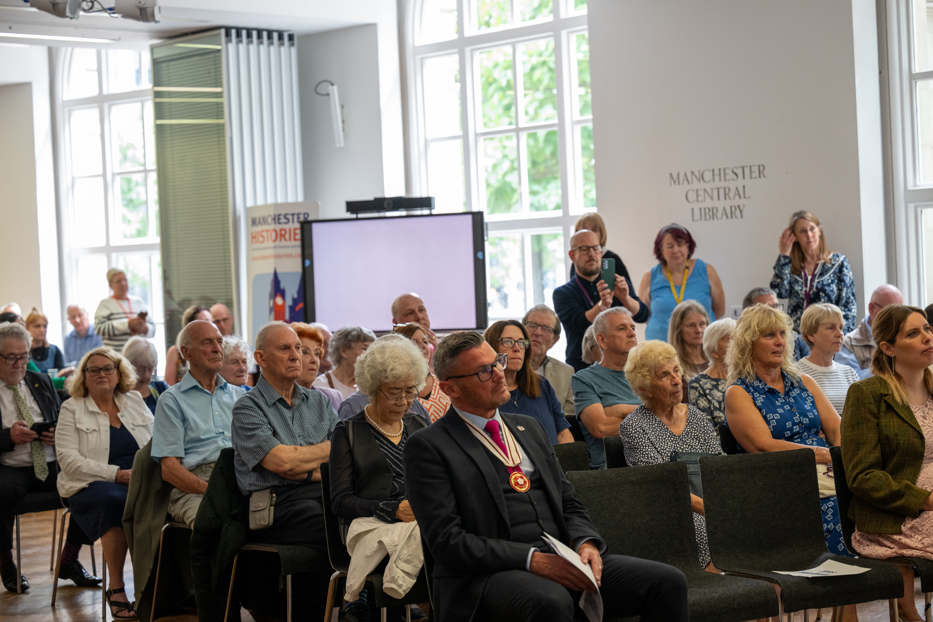 Library guest gather with council officials in the MCL
